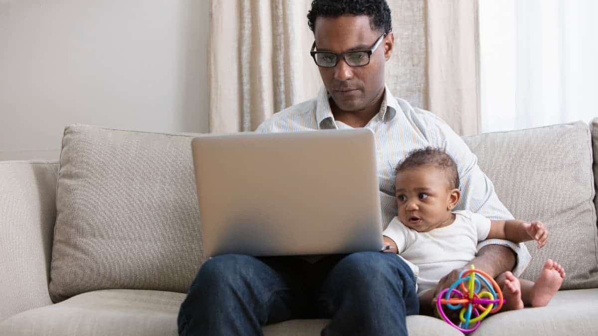 Father working from home and taking care of baby