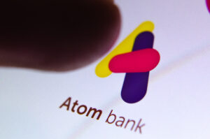 Atom Bank has pushed back its flotation by at least two years after tapping backers for another £30 million, giving it a post-deal valuation of £460 million.