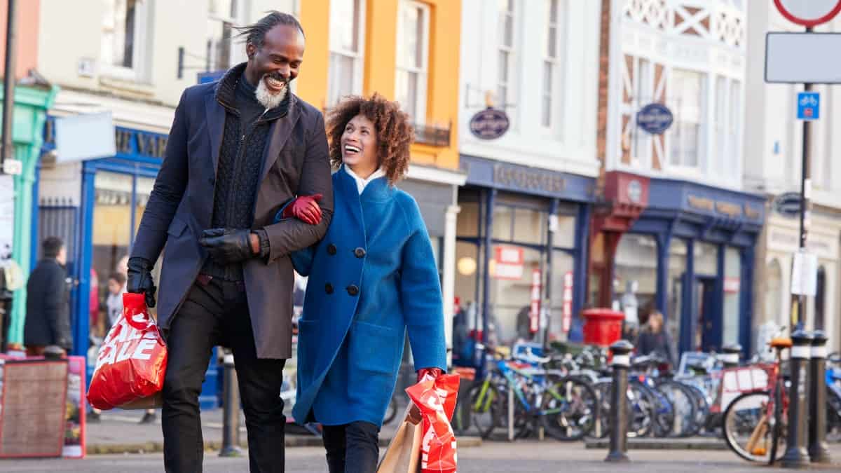 Mature black couple enjoying shopping together in UK high street