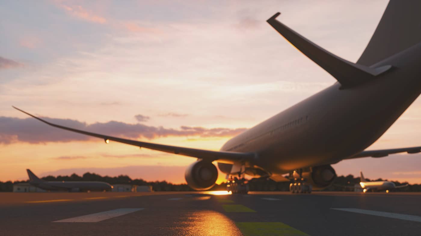 Jumbo jet preparing to take off on a runway at sunset