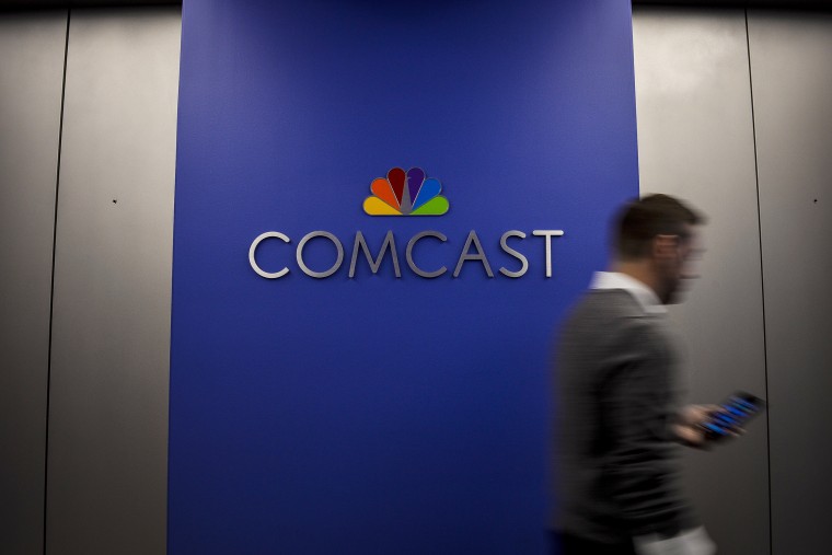 Image: An employee walk past signage inside Comcast Corp. headquarters in Philadelphia on Oct. 24, 2016.