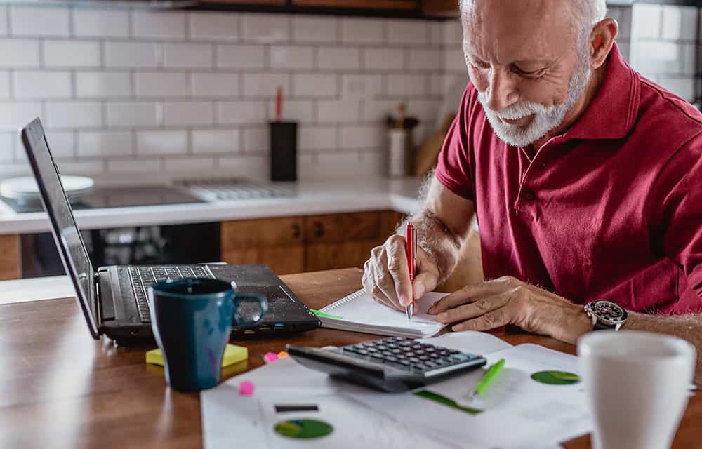 A senior man shortlisting stocks at his kitchen table