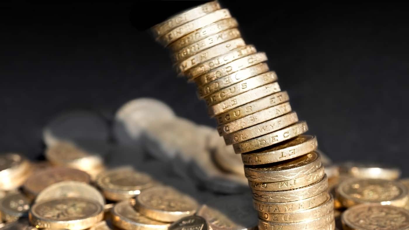 Stack of one pound coins falling over