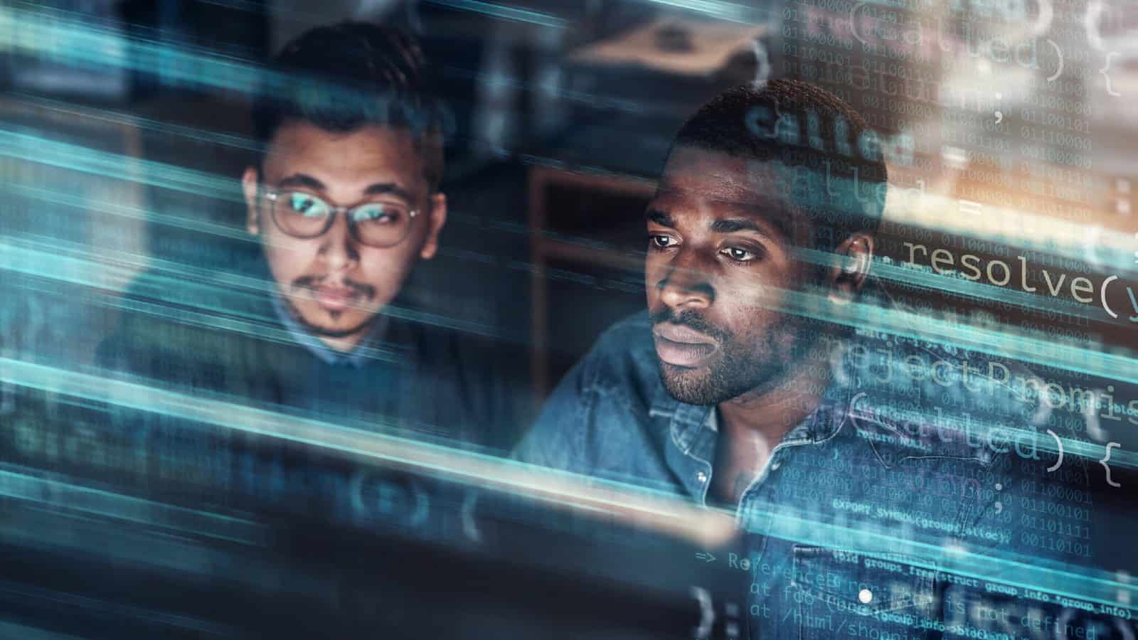 Concept of two young professional men looking at a screen in a technological data centre