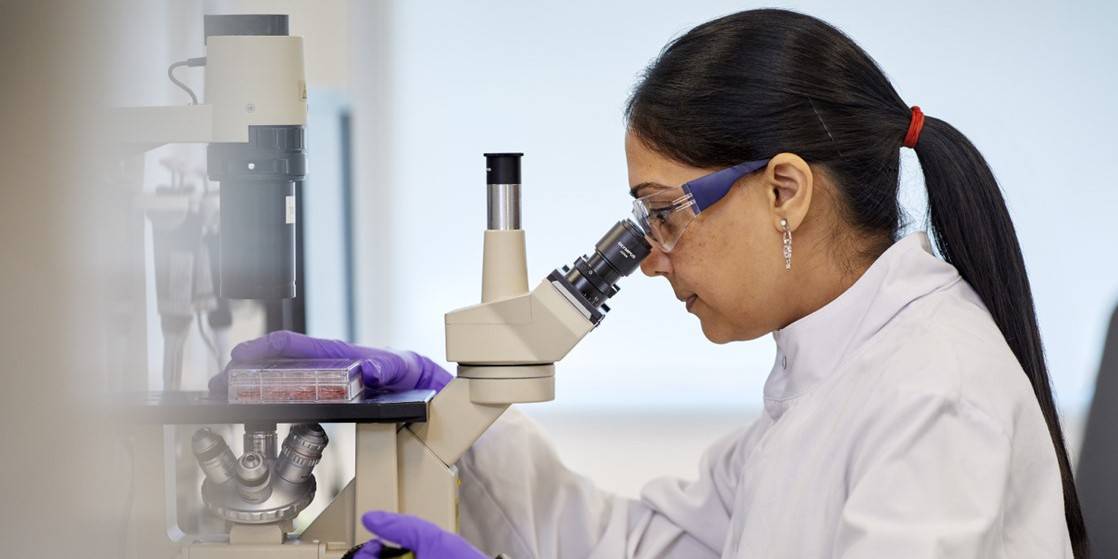 A GlaxoSmithKline scientist uses a microscope