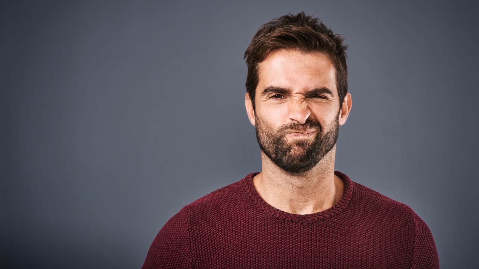 Young Caucasian man making doubtful face at camera