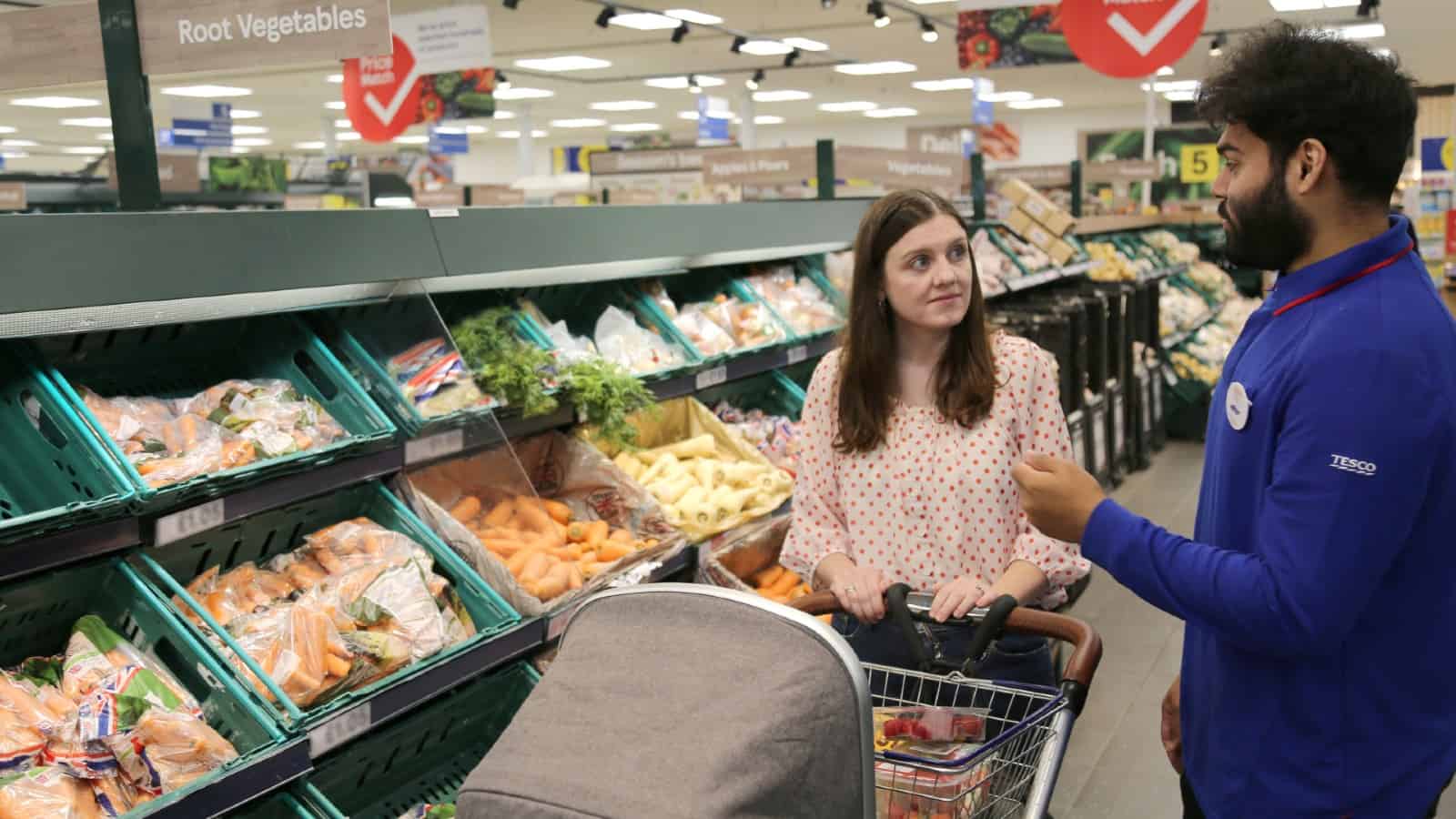 Tesco employee helping female customer