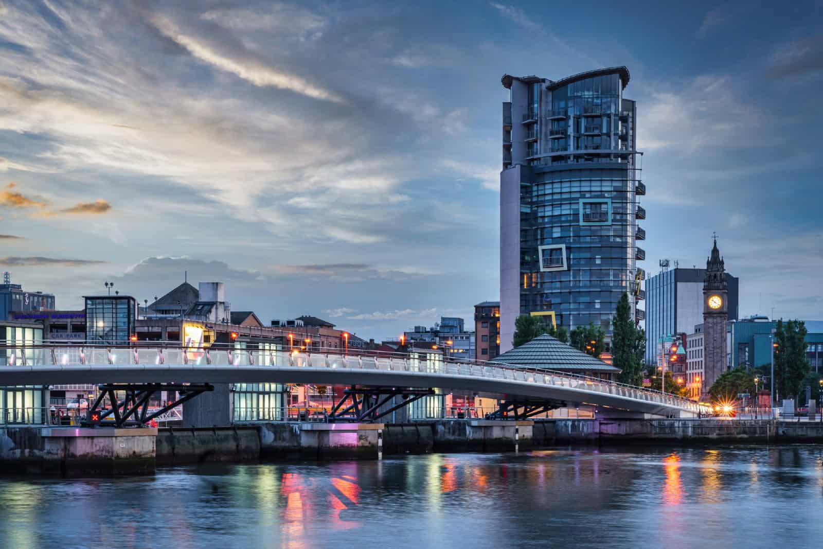 Belfast City Sunset with colorful twilight over Lagan Weir Pedestrian and Cycle Bridge spanning over the Lagan River in downtown Belfast