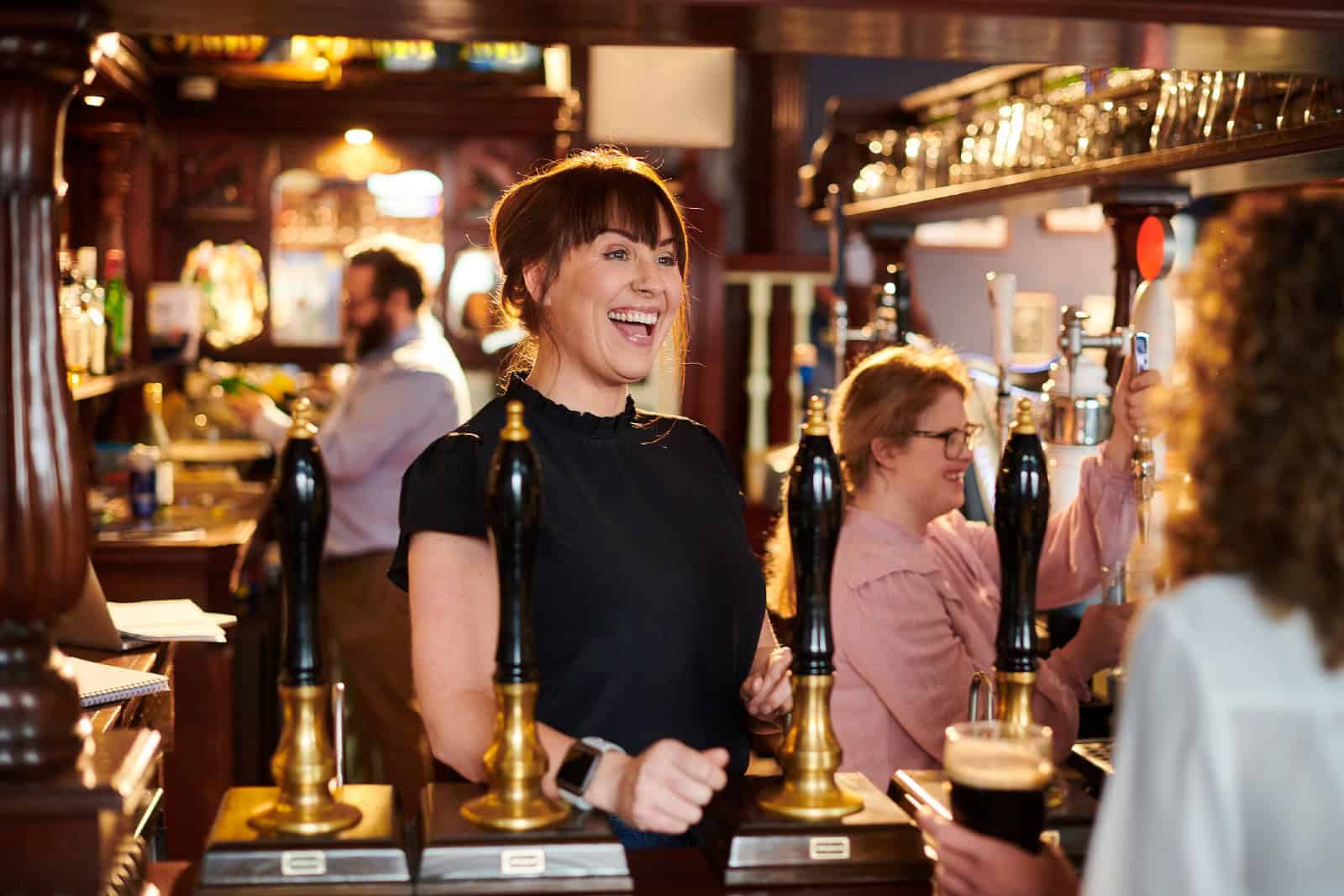 Landlady greets regular at real ale pub