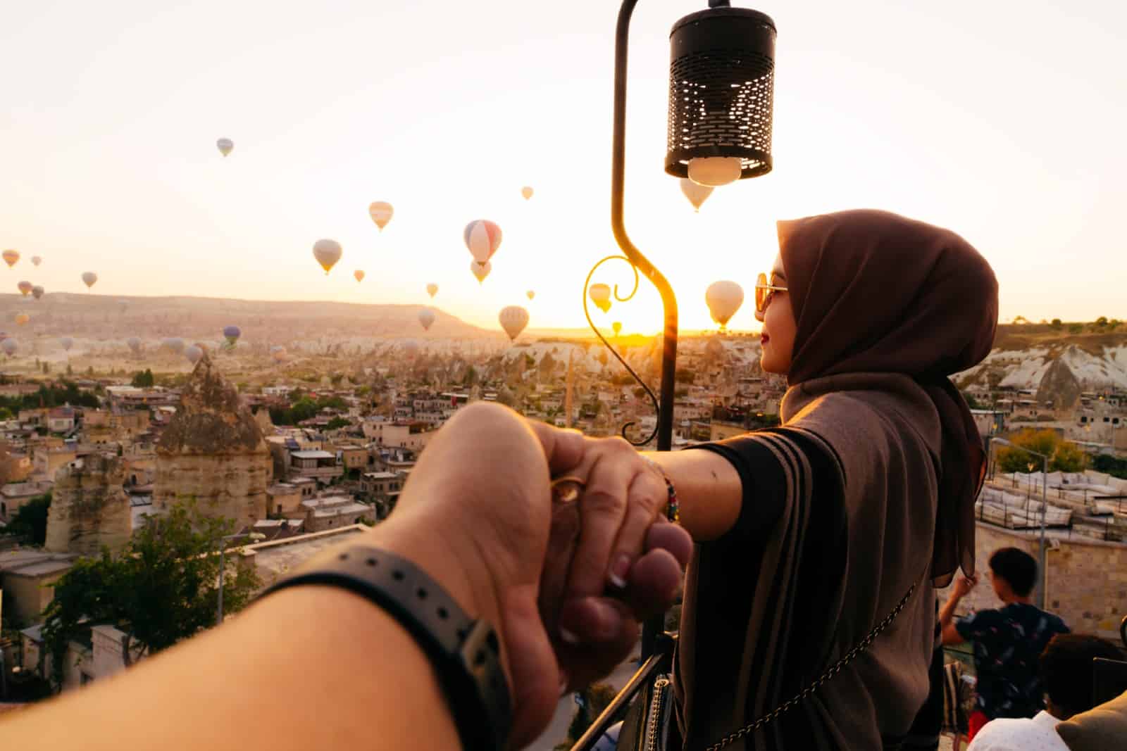 Rear View Of Woman Holding Man Hand during travel in cappadocia