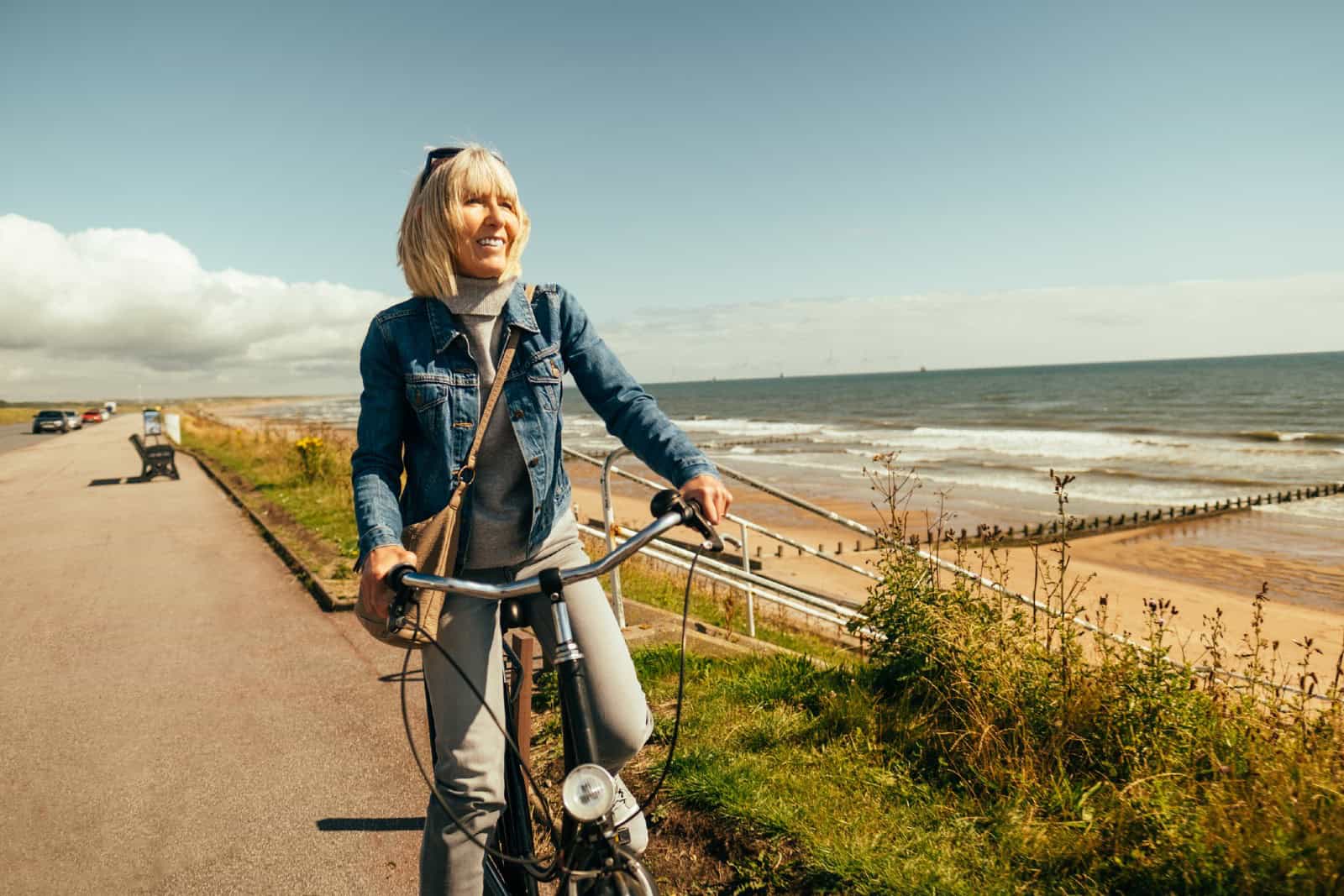 Woman riding her old fashioned bicycle along the Beach Esplanade at Aberdeen, Scotland.